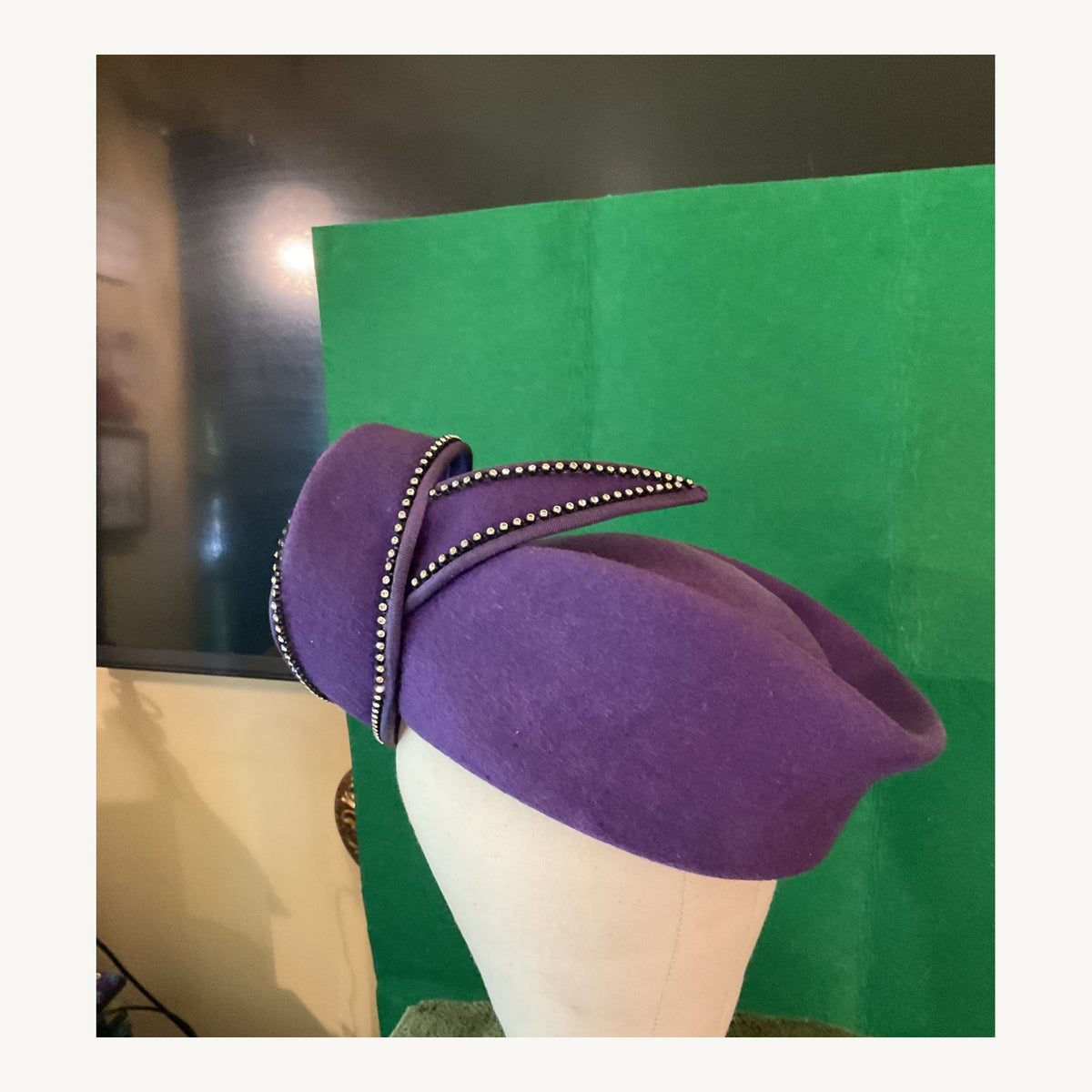 Royal purple sculptural occasion hat with crystal-edged curled design, pre-owned.
