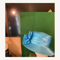 Sapphire blue satin-look occasion hat with large sculptural floral detail, pre-owned.