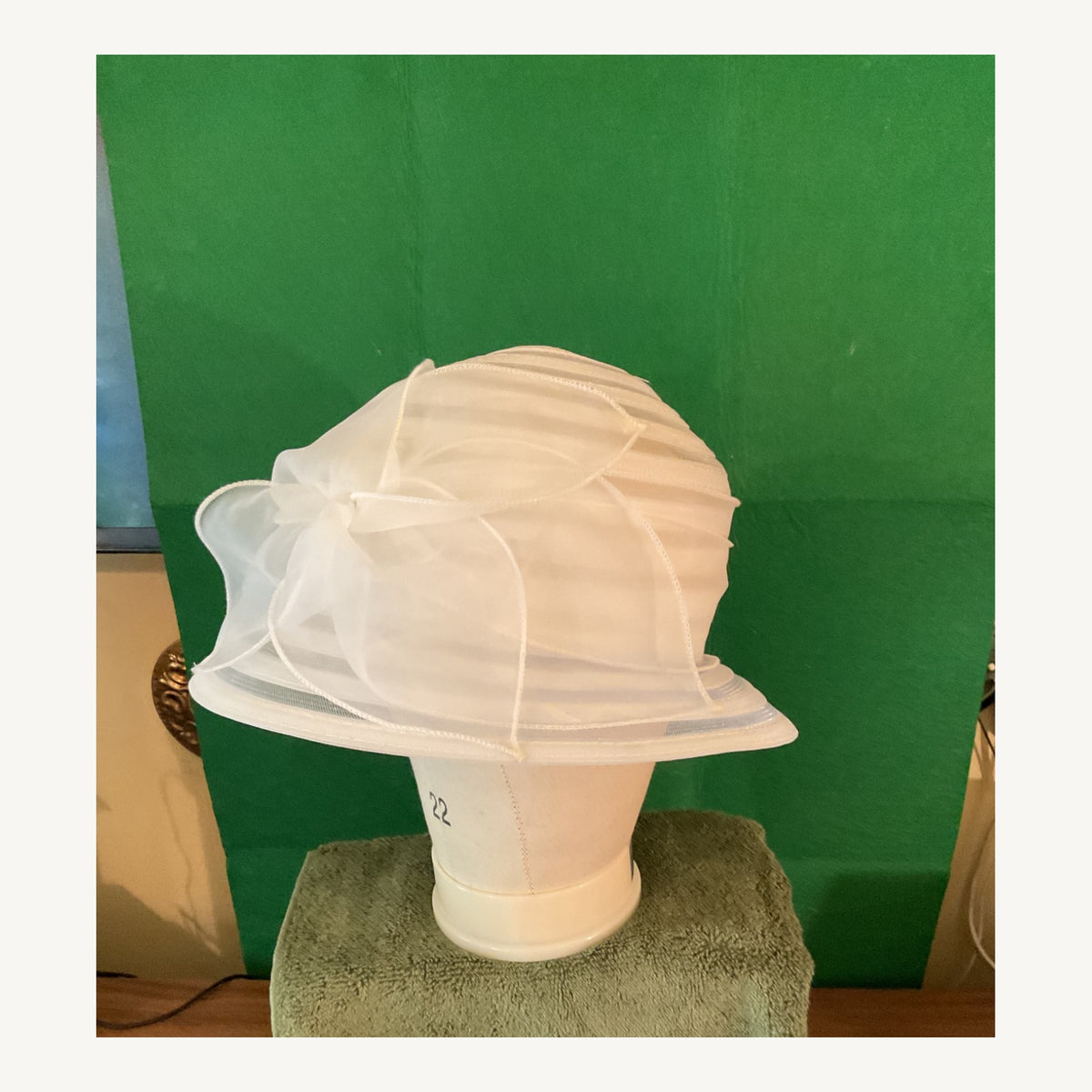 White sheer sculptural cloche-style occasion hat with layered translucent bands and bow detail, pre-owned.