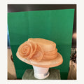 Peach structured occasion hat with layered rose embellishment, pre-owned.