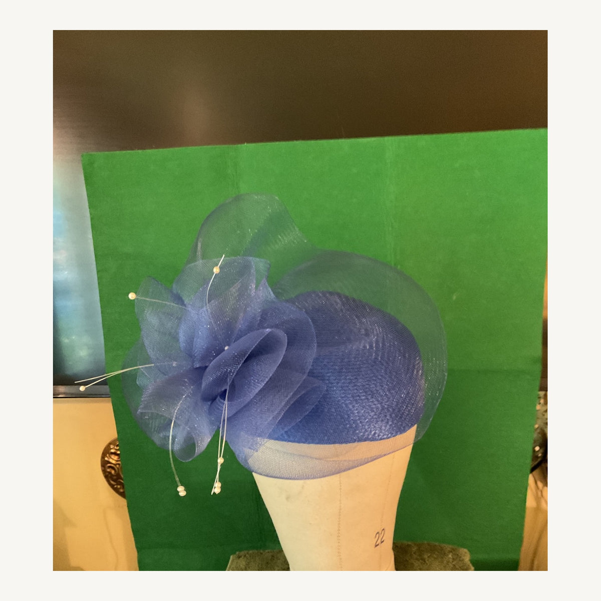 Navy blue fascinator-style occasion hat with large organza floral loops and pearl-tipped accents, pre-owned.