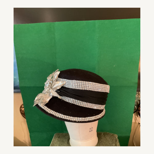 Black occasion hat with silver crystal bands and large silver floral embellishment, pre-owned.
